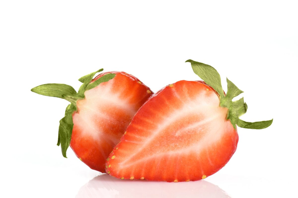 Deux moitiés de fraises juteuses isolées sur fond blanc.